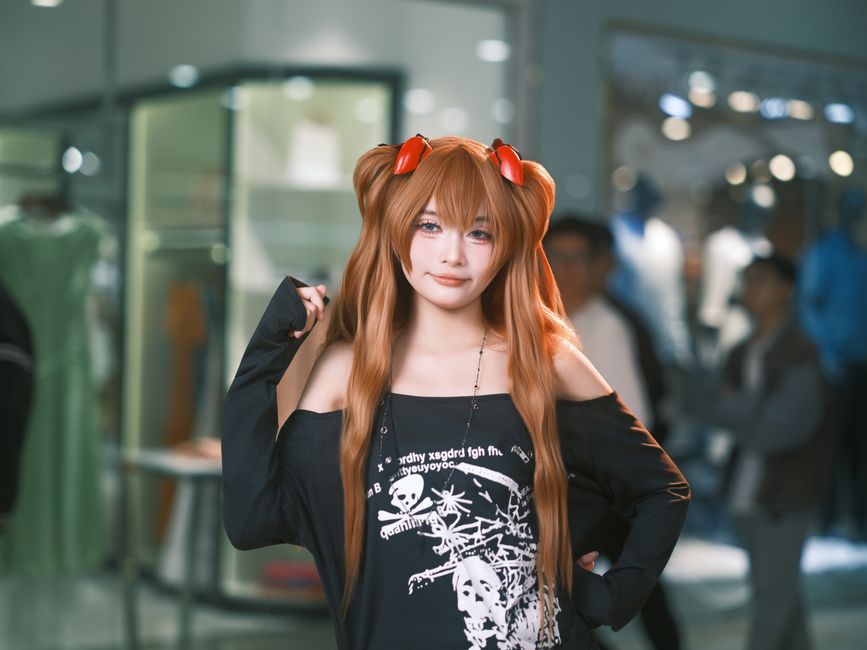 A cosplay character poses with a sword outdoors, displaying intricate costume design.