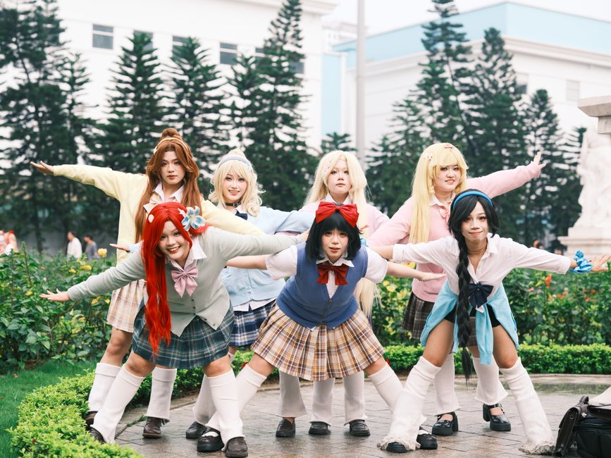 Group of cosplayers in colorful outfits posing outdoors in Vietnam.