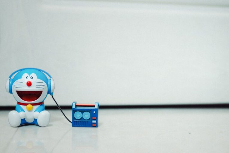 A cute blue cartoon toy listening to music with headphones. Perfect for children's themes.