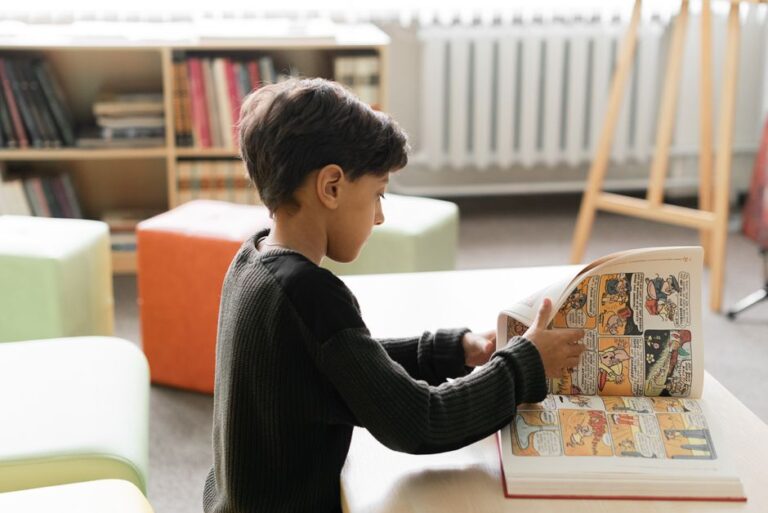 Young boy reading a comic book in a cozy library. Captured indoors on a quiet day.