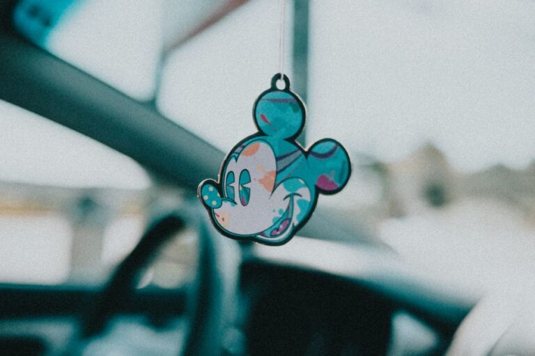 Close-up of a vibrant Mickey Mouse keychain hanging inside a car for a whimsical touch.
