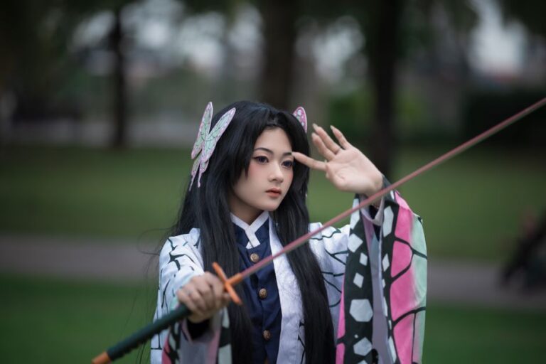 A cosplayer dressed as a character with a sword in a serene park setting.