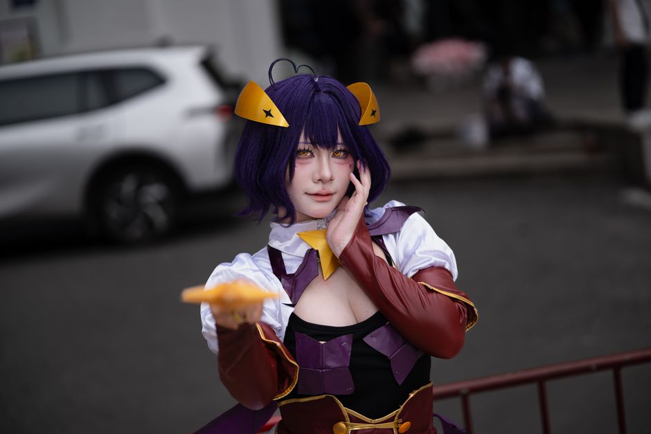 A cosplayer dressed as a character with a sword in a serene park setting.