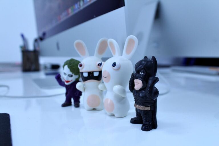 Close-up of various cartoon figurines on a modern desk setting, perfect for creativity-themed projects.