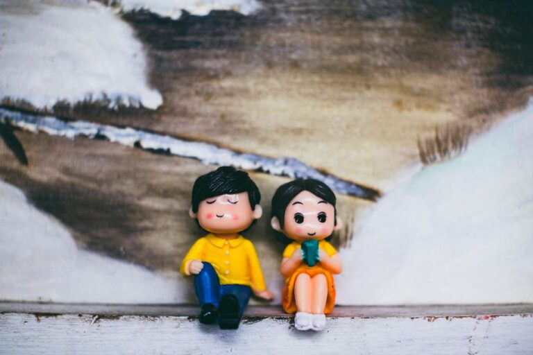 Figures of man with female beloved sitting against artwork of river and meadows with snow in countryside